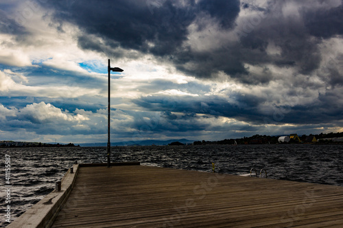 the lantern at the end of the pier with gloomy weather
