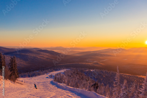 Ski trail at sunset. Mountains covered with forest