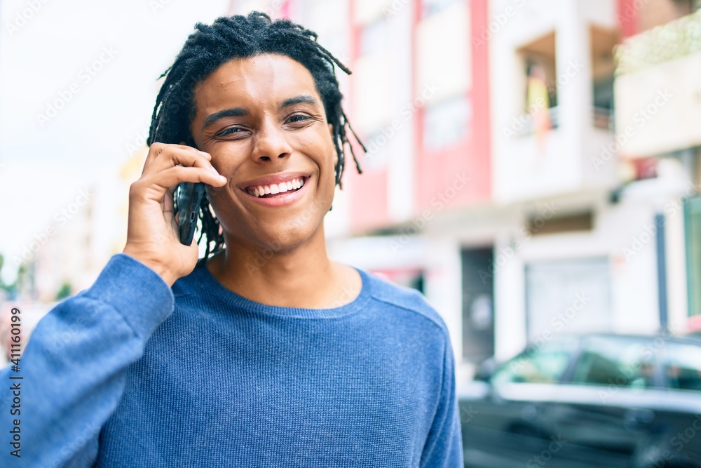 Young african american man smiling happy talking on the smartphone at street of city. Young african american man smiling happy talking on the smartphone at street of city.