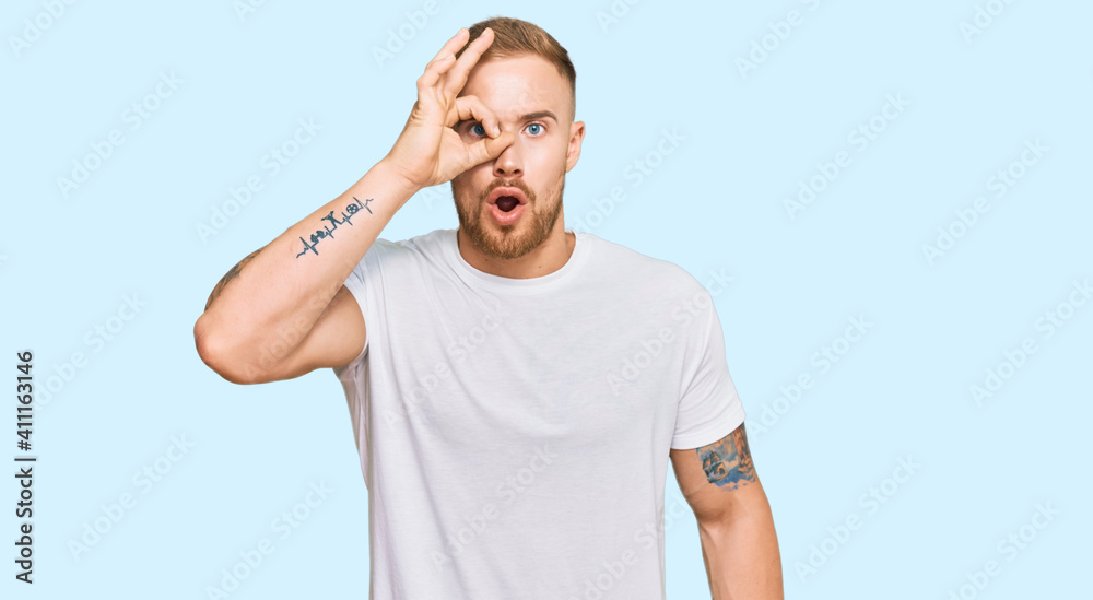 Young irish man wearing casual clothes doing ok gesture shocked with surprised face, eye looking through fingers. unbelieving expression. Young irish man wearing casual clothes doing ok gesture shocked with surprised face, eye looking through fingers. unbelieving expression.