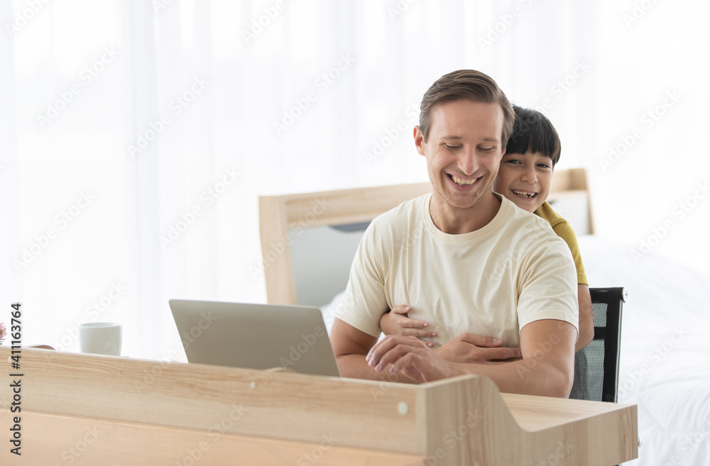 Caucasian dad and mixed-race son cuddle and playing together in fun and intimate manner Caucasian dad and mixed-race son cuddle and playing together in fun and intimate manner