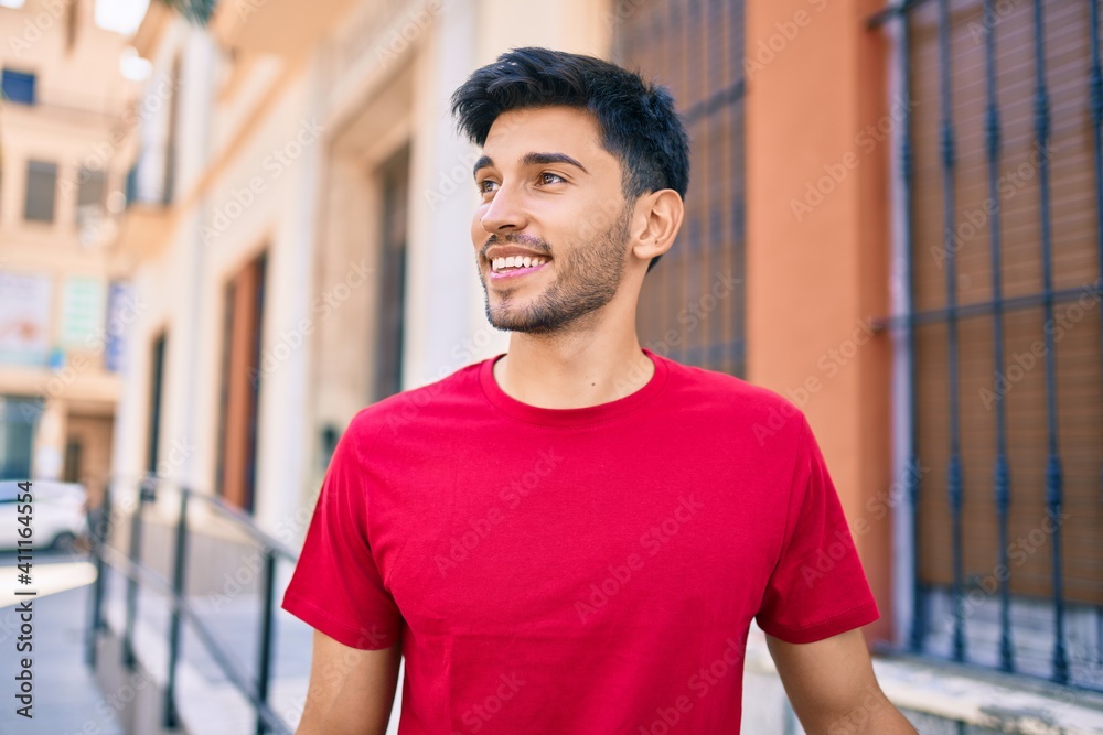 Young latin man smiling happy walking at the city. Young latin man smiling happy walking at the city.