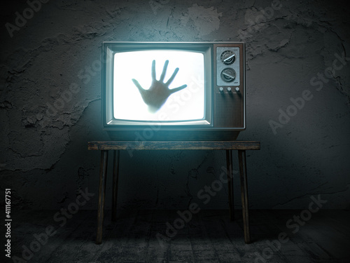 Horror scary movie concept. Hand of ghost on screen of vintage tv in haunted house. photo