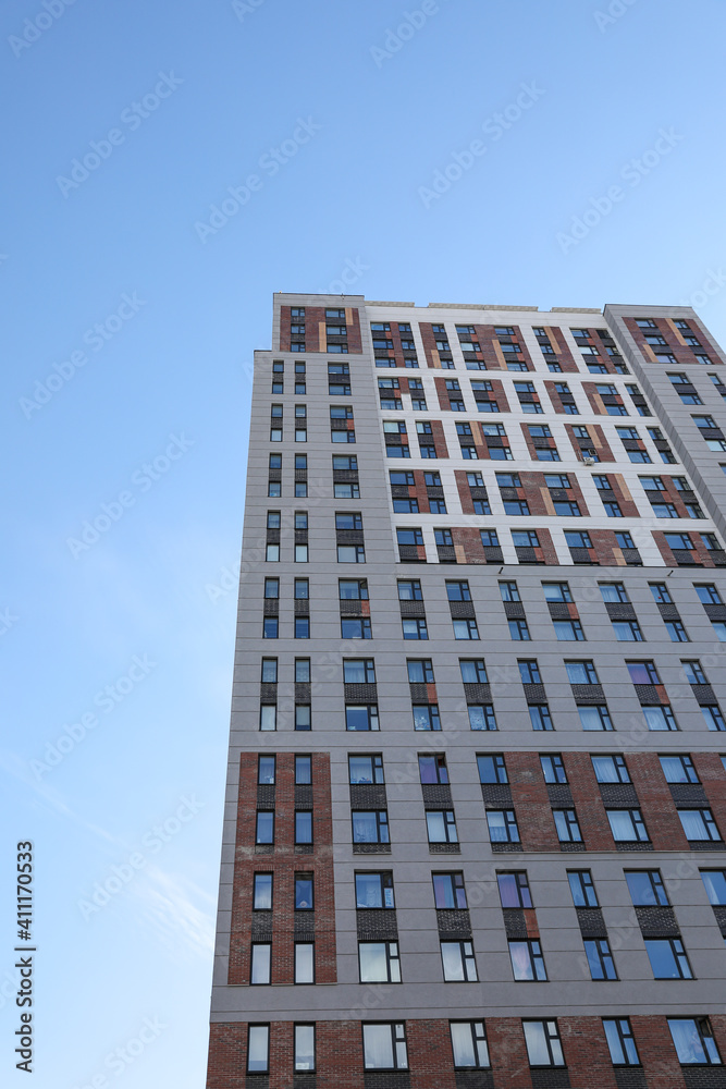 A modern high-rise building against a blue sky. New modern construction