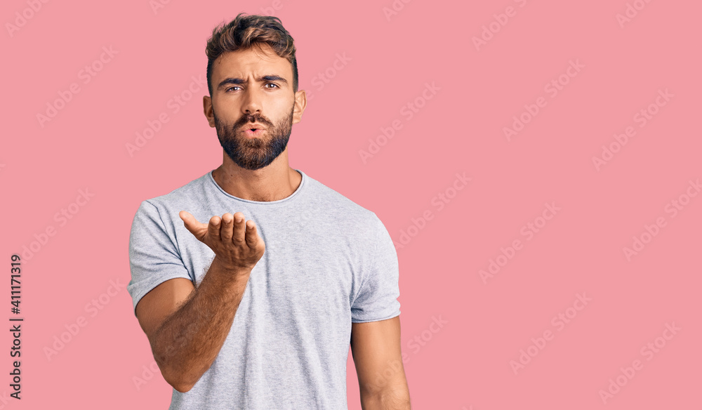 Young hispanic man wearing casual clothes looking at the camera blowing a kiss with hand on air being lovely and sexy. love expression. Young hispanic man wearing casual clothes looking at the camera blowing a kiss with hand on air being lovely and sexy. love expression.