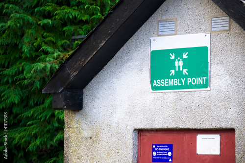 Fire assembly point sign at workplace signpost