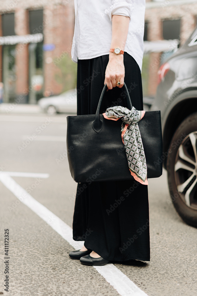 Fototapeta premium A woman with a bag on the background of the city