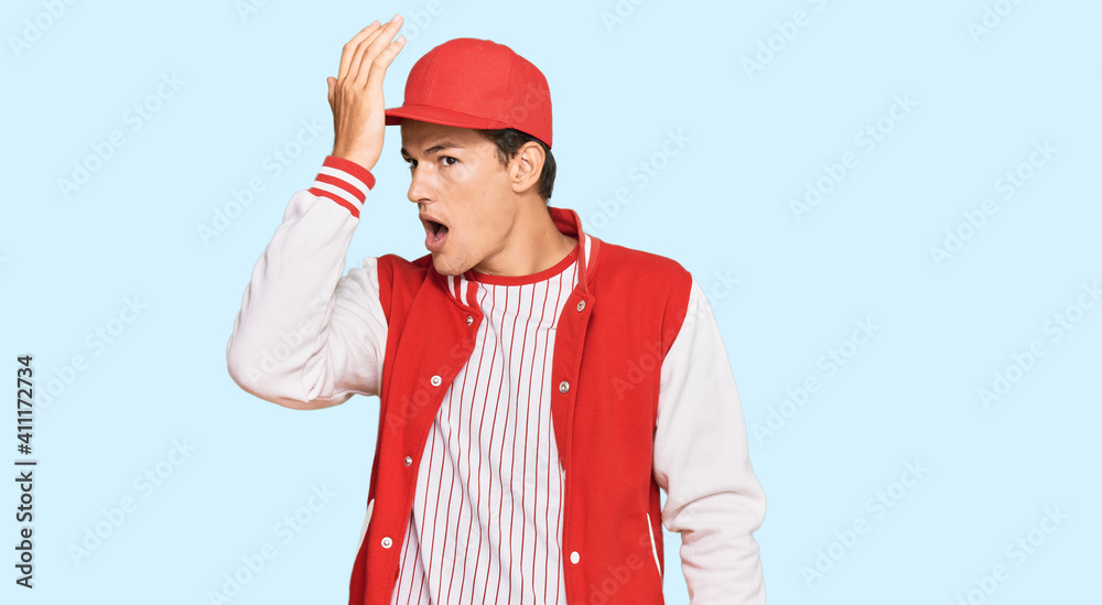 Handsome caucasian man wearing baseball uniform surprised with hand on head for mistake, remember error. forgot, bad memory concept. Handsome caucasian man wearing baseball uniform surprised with hand on head for mistake, remember error. forgot, bad memory concept.