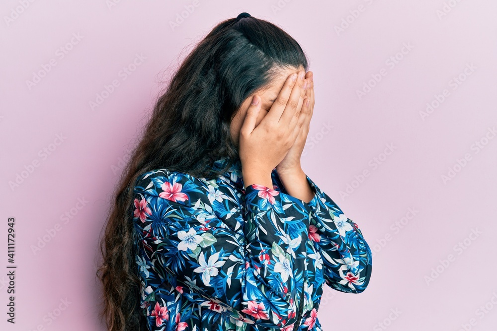 Beautiful middle eastern woman wearing casual floral jacket with sad expression covering face with hands while crying. depression concept. Beautiful middle eastern woman wearing casual floral jacket with sad expression covering face with hands while crying. depression concept.