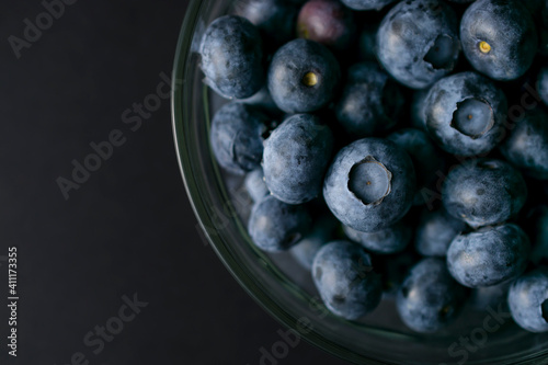 Bowl of blueberries on black background. Macro photography of fresh blueberries. Ripe blueberries background. Blueberries texture. Food photography collection.