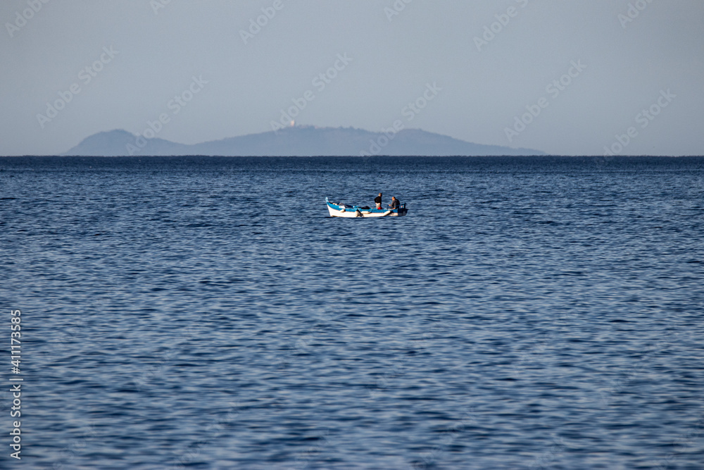 Barca di pescatori e sullo sfondo l'Isola di Ustica