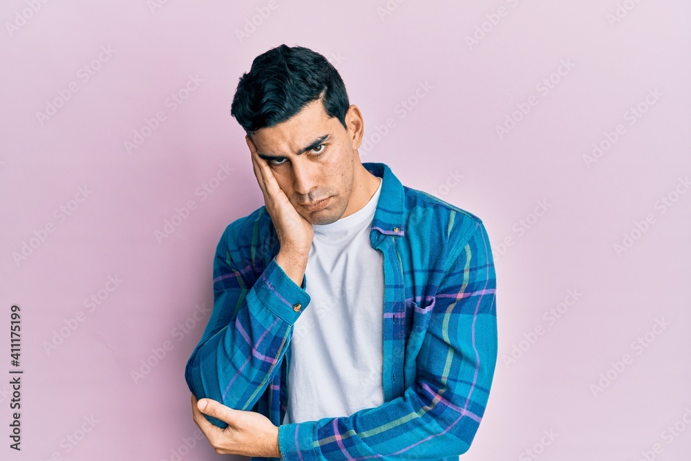 Fototapeta premium Handsome hispanic man wearing casual clothes thinking looking tired and bored with depression problems with crossed arms.