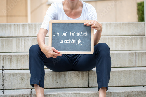 Frau mit einer Tafel auf der steht Ich bin finanziell unabhängig