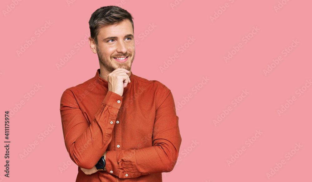 Fototapeta premium Handsome caucasian man wearing casual clothes with hand on chin thinking about question, pensive expression. smiling with thoughtful face. doubt concept.