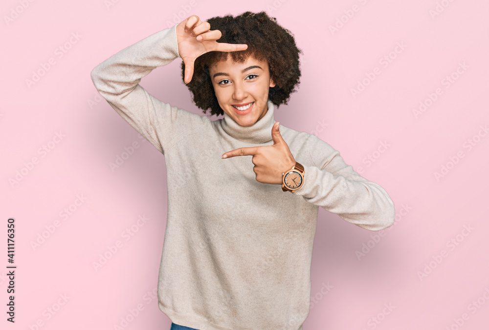 Young hispanic girl wearing wool winter sweater smiling making frame with hands and fingers with happy face. creativity and photography concept. Young hispanic girl wearing wool winter sweater smiling making frame with hands and fingers with happy face. creativity and photography concept.