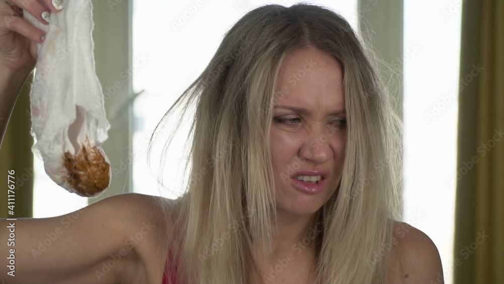 Young unhappy woman mom holding a dirty baby diaper, slow motion