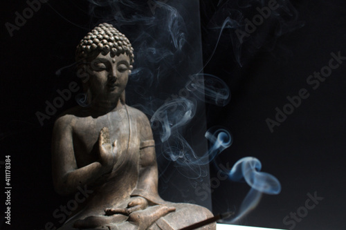 Buddha statue with incense stick meditating people home practice mindfulness yoga meditation concept  photo