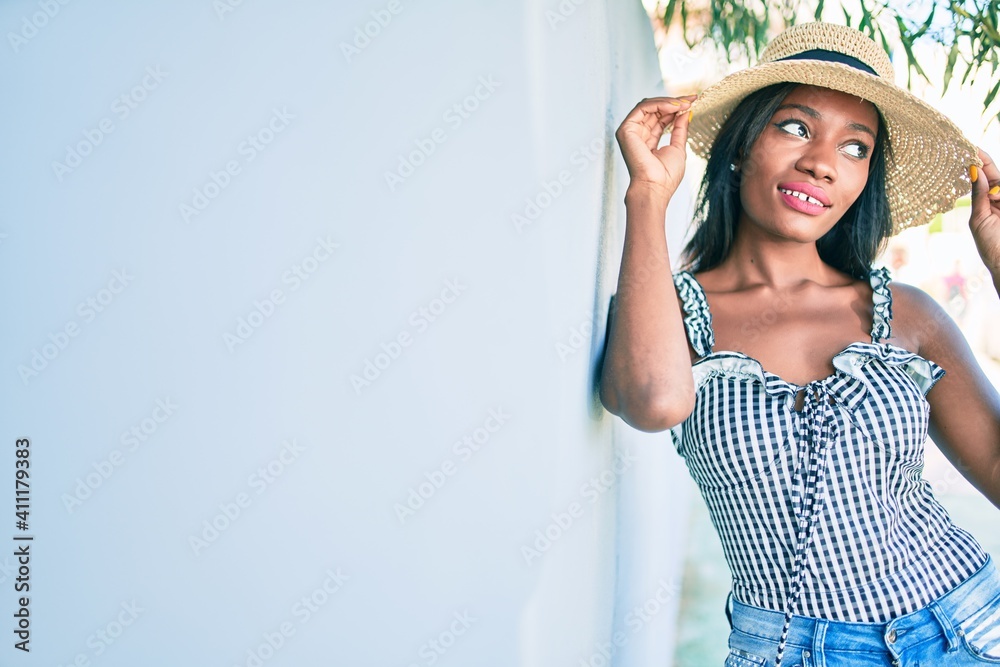 Young african american woman on vacation smiling happy leaning on the wall at street of city Young african american woman on vacation smiling happy leaning on the wall at street of city