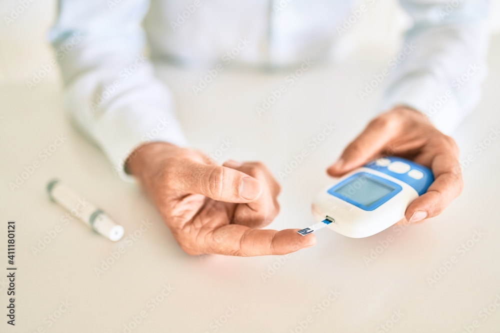 Close up of man with diabetes using insuline glucometer with blood from the finger Close up of man with diabetes using insuline glucometer with blood from the finger