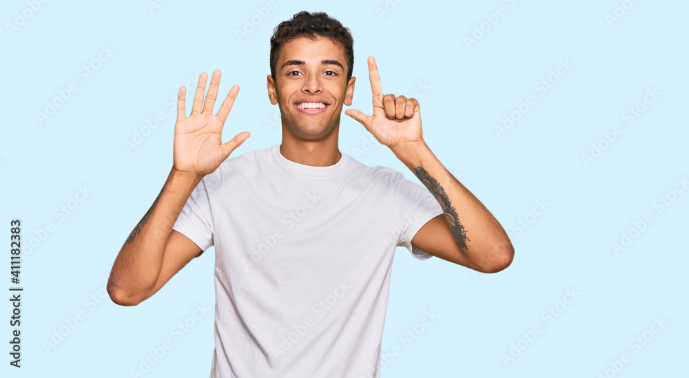 Young handsome african american man wearing casual white tshirt showing and pointing up with fingers number seven while smiling confident and happy. Young handsome african american man wearing casual white tshirt showing and pointing up with fingers number seven while smiling confident and happy.