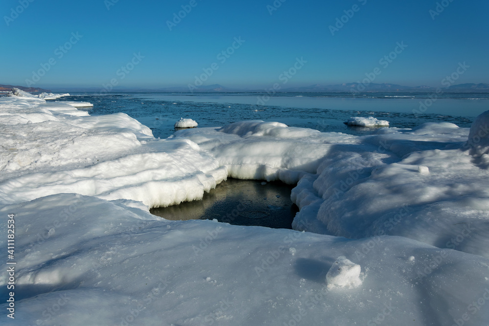 Frozen rocks in the sea on a sunny winter day. Frozen rocks in the sea on a sunny winter day.