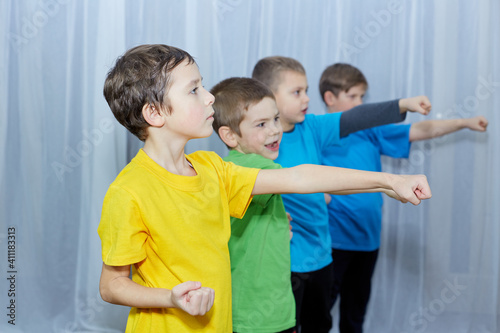 Boys in multicolored t-shirts beat a punch on a light background