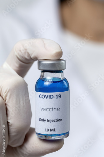 COVID-19 vaccine in researcher hands, unrecognizable female doctor holds syringe