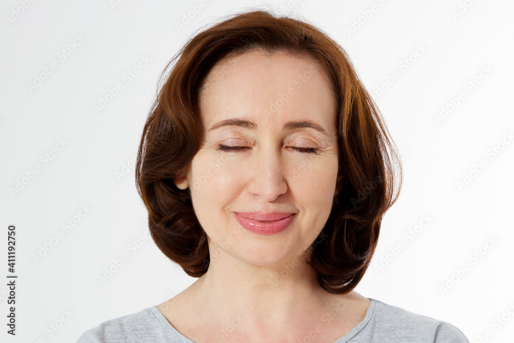 Closeup beautiful middle aged woman face isolated on white background with copy space. Anti aging lifting treatment and skincare routine. Menopausal female period and healthy anti-aging lifestyle