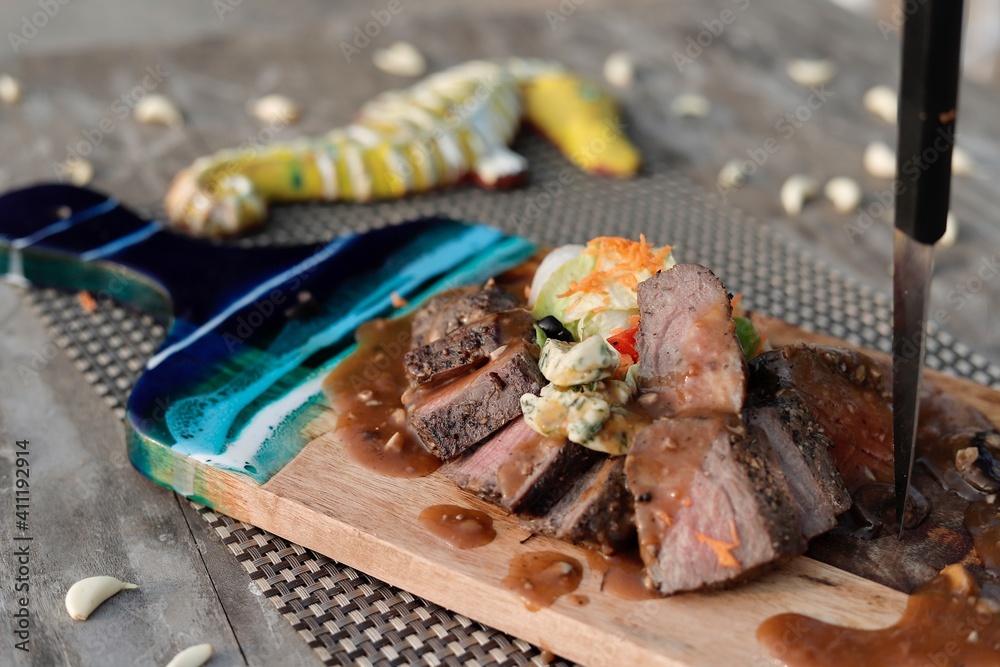 grilled steak chops on an wooden board grilled steak chops on an wooden board