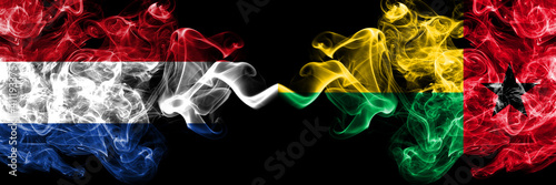 Netherlands vs Guinea Bissau smoky mystic flags placed side by side. Thick colored silky abstract smoke flags.