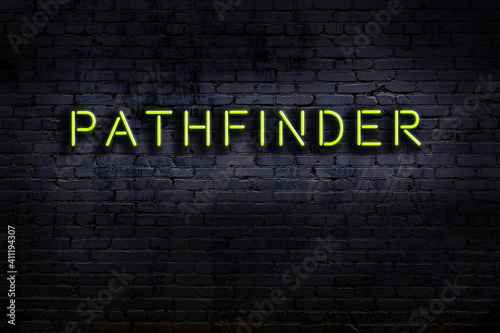 Neon sign. Word pathfinder against brick wall. Night view photo
