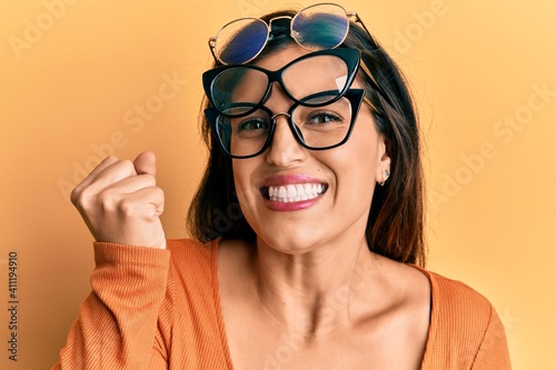 Canvas-taulu Beautiful hispanic woman wearing many glass over face screaming proud, celebrati