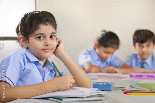 school girl sitting in class and looking at the camera 