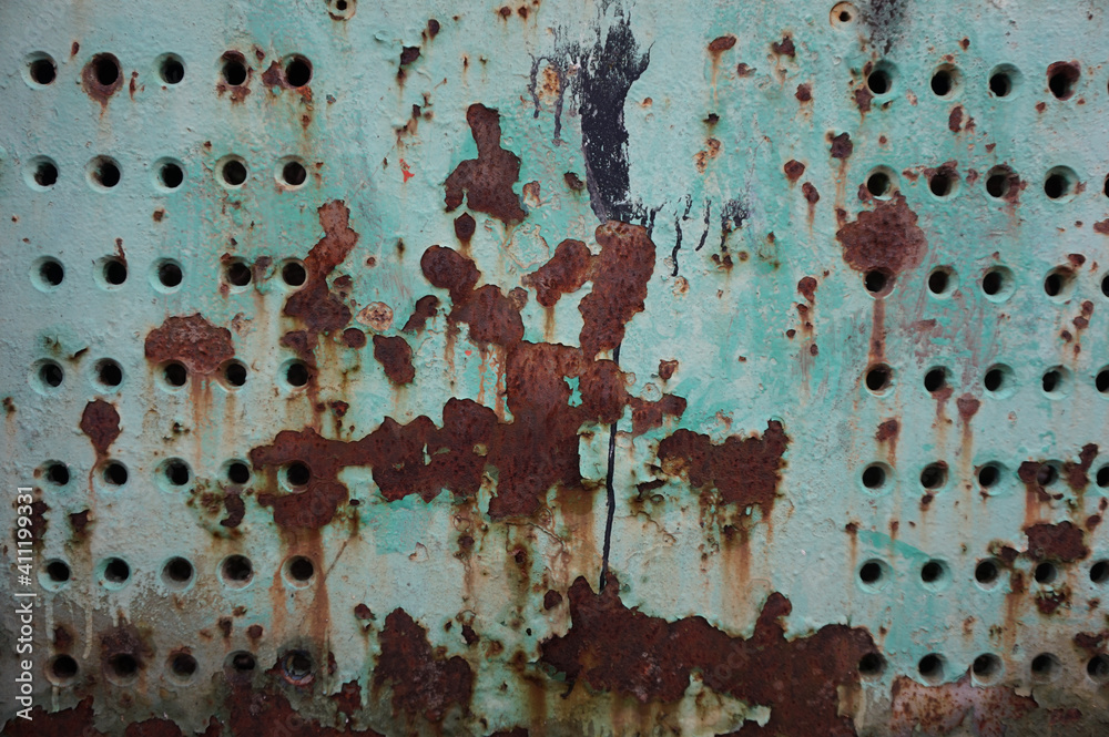 Light green paint and rusty metal background with holes