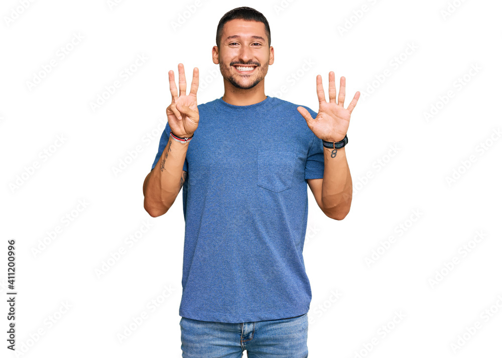 Handsome man with tattoos wearing casual clothes showing and pointing up with fingers number eight while smiling confident and happy. Handsome man with tattoos wearing casual clothes showing and pointing up with fingers number eight while smiling confident and happy.
