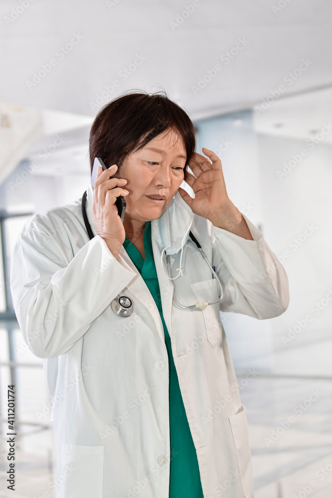 Desperate looking female doctor using her phone Desperate looking female doctor using her phone