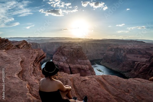 Eine junge Frau genießt den Sonnenuntergang beim berühmten Horseshoe Bend nahe der Stadt Page, Utah -USA. photo