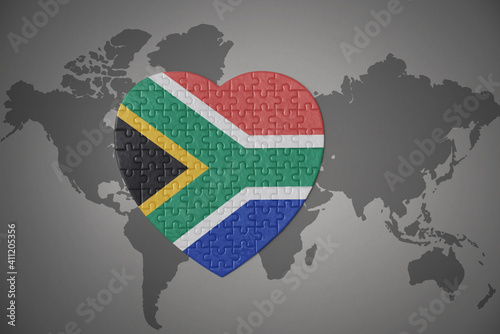 Fotografie puzzle heart with the national flag of south africa on a world map background
