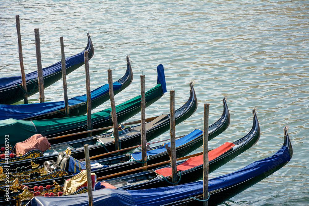 Group of gondolas moored at a dock of the Grand Canal in Venice