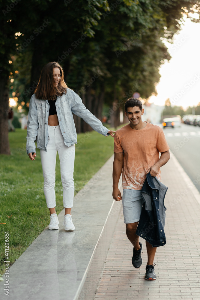 Cheerful couple enjoying walking in the city. Casual style people. Couple in love in the city. Urban lovestory Cheerful couple enjoying walking in the city. Casual style people. Couple in love in the city. Urban lovestory