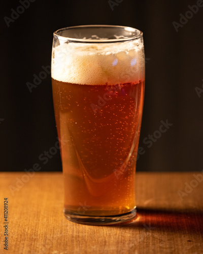 A glass of delicious craft beer served on an authentic beer glass, to be used as a background.