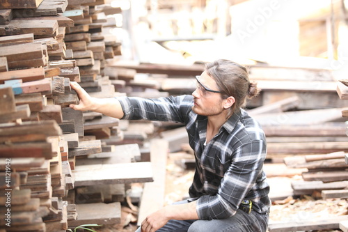 Carpenter, he is working in the workshop. Man at work on wood. Image of mature carpenter in the workshop, furniture making concept.