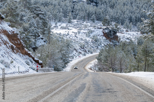 scenic view of the road in the forest with snow covered.