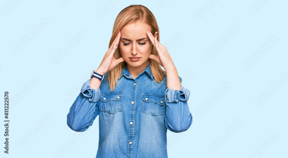 Beautiful caucasian woman wearing casual denim jacket with hand on head for pain in head because stress. suffering migraine. Beautiful caucasian woman wearing casual denim jacket with hand on head for pain in head because stress. suffering migraine.