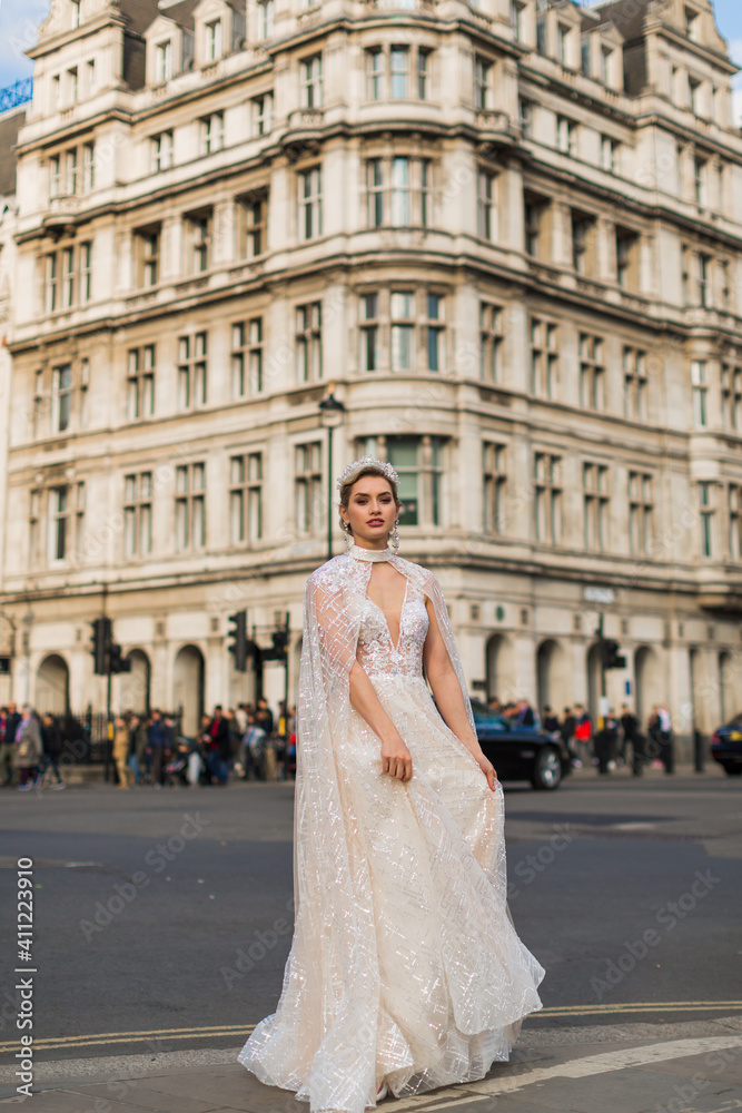the bride in a ivory dress and veil, background architecture, people and street