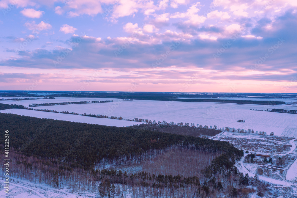 Aerial view of winter snowy countryside at sunset