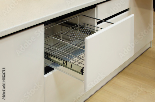 Modern kitchen, storage space for plates, drawer in luxury kitchen.