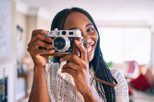 Young african american woman smiling happy using camera at home