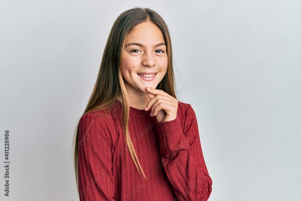 Beautiful brunette little girl wearing casual sweater smiling looking confident at the camera with crossed arms and hand on chin. thinking positive. Beautiful brunette little girl wearing casual sweater smiling looking confident at the camera with crossed arms and hand on chin. thinking positive.