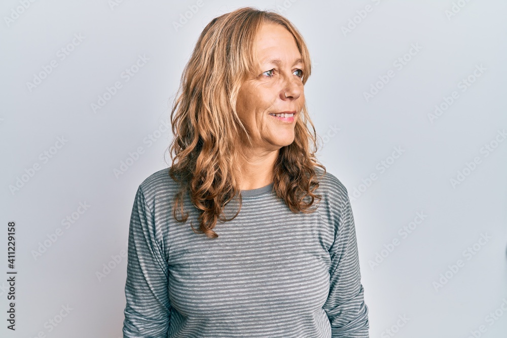 Middle age blonde woman wearing casual clothes looking to side, relax profile pose with natural face and confident smile.